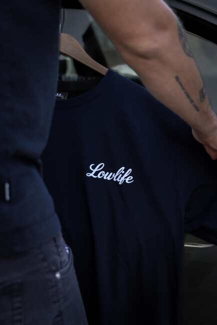 Schwarzes Lowlife Shirt mit weißem Logo auf einem Kleiderbügel
